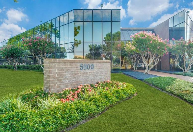 Exterior of the modern glass-fronted office building at 5600 Northwest Central Drive.