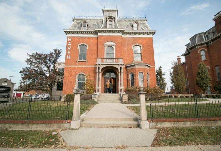 Historic red brick building exterior with a grand portico entrance.