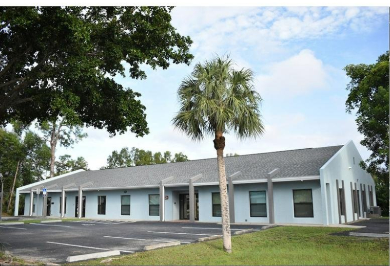 Exterior view of the light blue one-story office building at 6361 Presidential Court.