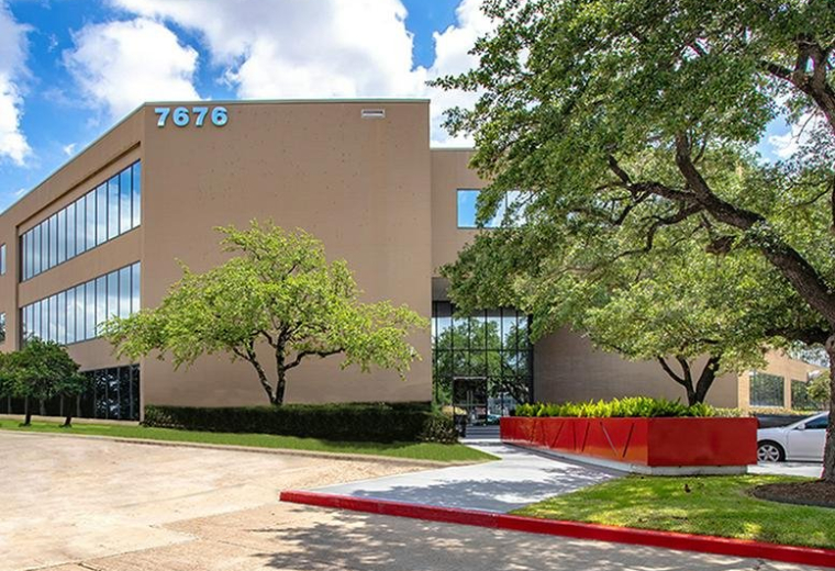 Exterior view of the multi-story office building at 7676 Hillmont, Houston, Texas with manicured landscaping.