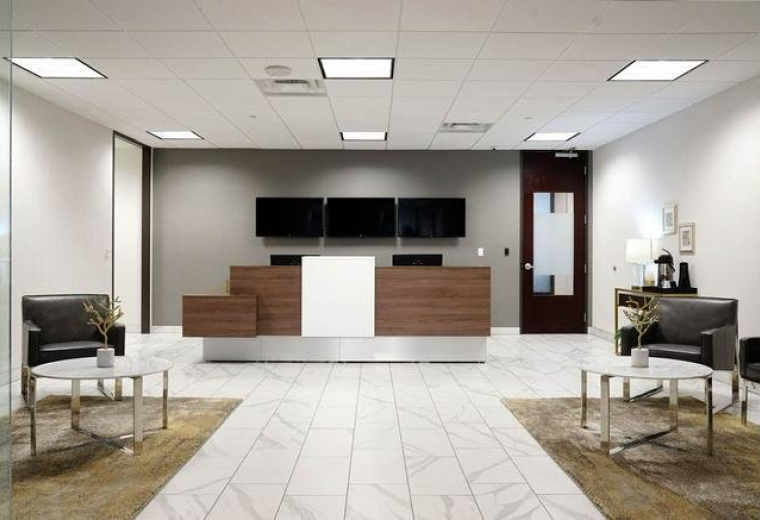 Bright lobby area with a modern wood reception desk and white tiled floor.