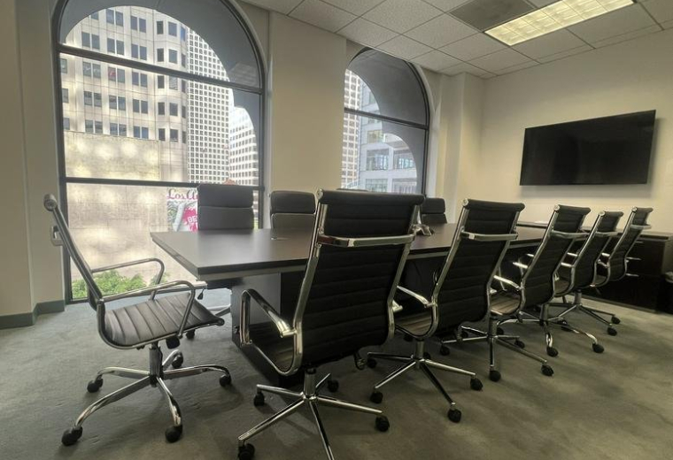 Spacious boardroom at 835 Wilshire Boulevard Suite 500 featuring arched windows and city views.