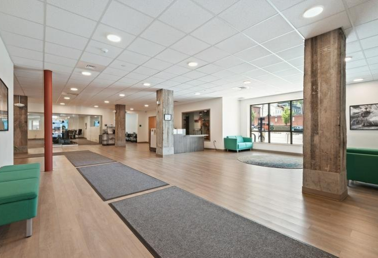 Spacious lobby area with green seating and large windows.