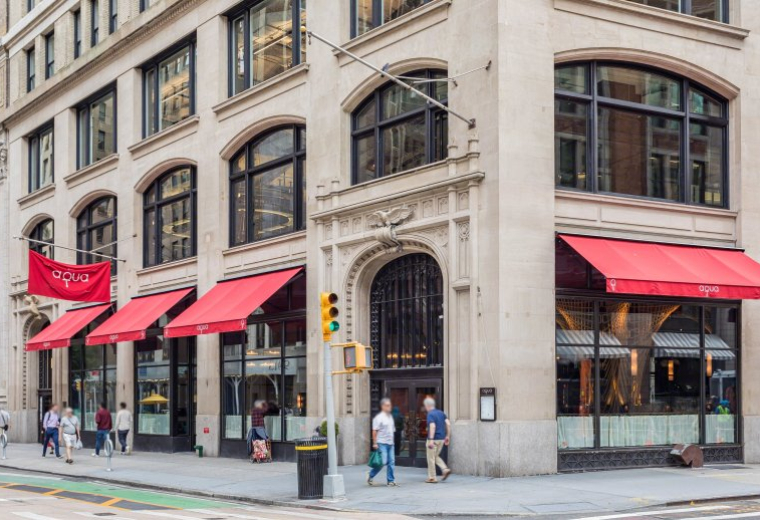 Exterior view of the historic stone facade and red awnings at 902 Broadway.