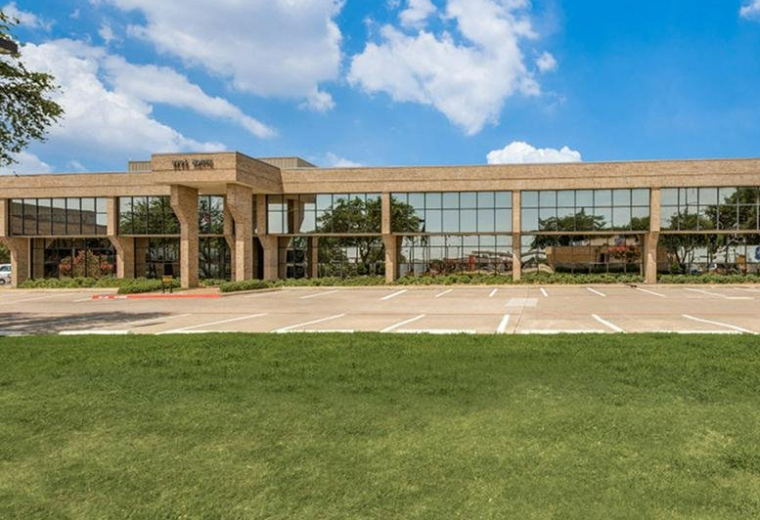 Exterior view of the tan brick and glass building at 9304 Forest Lane.