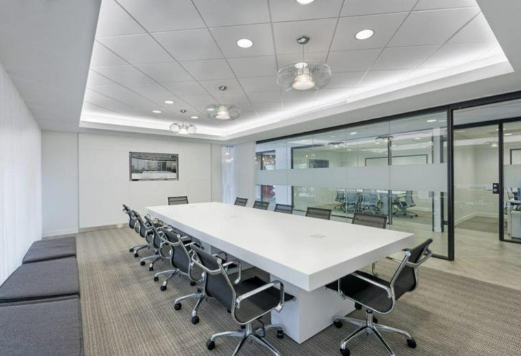 Spacious boardroom with a large white table and black chairs at 95 Merrick way, 3rd Floor.
