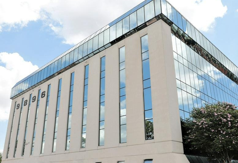 Exterior view of the multi-story glass and stone building at 9896 Bissonnet.