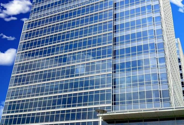 Exterior view of the glass-facade Calle Lago Alberto No. 319 building against a blue sky.