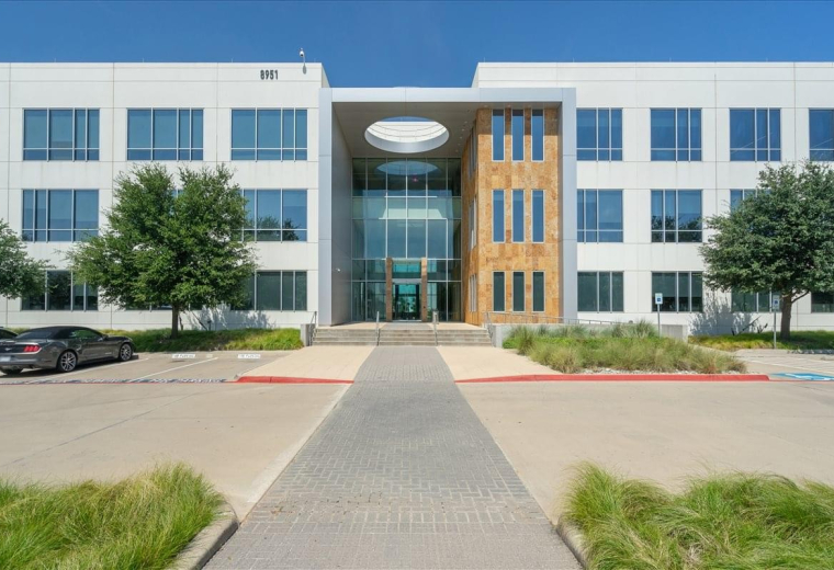 Exterior view of the modern glass and white facade at Cypress Waters, 8951 Cypress Waters Blvd.