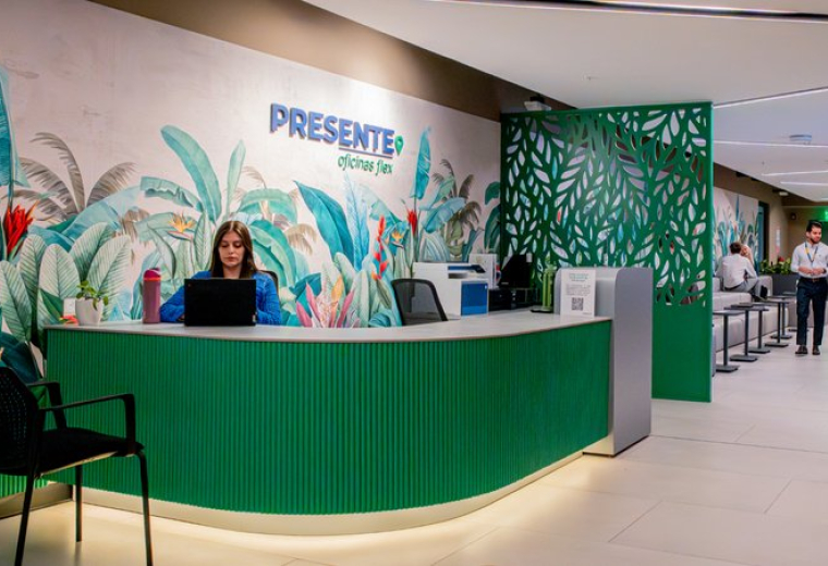 Green branded reception desk at Ruta Nacional Treciaria 310 with tropical wall art and bright lighting.
