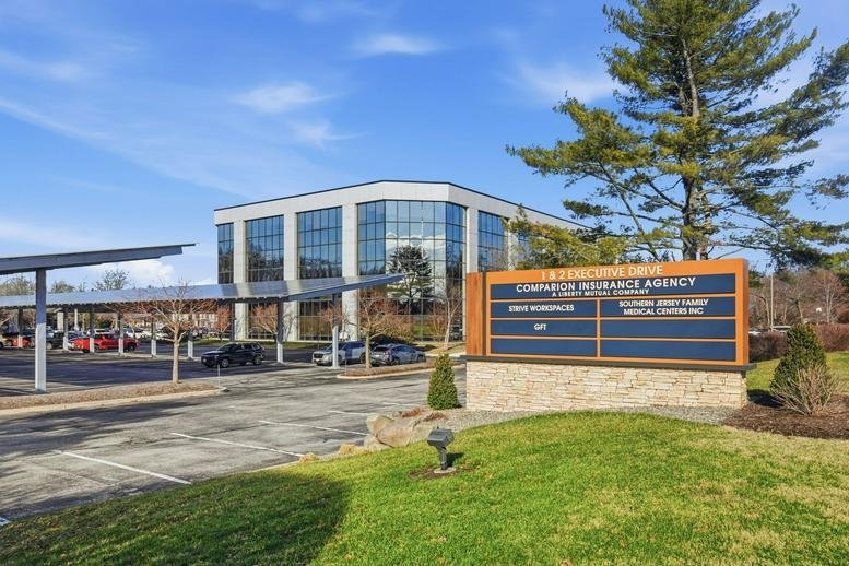 Exterior view of the multi-story glass facade building at 1, Executive Drive, Suite 100.
