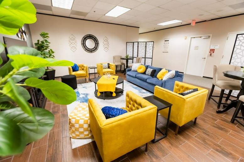 Vibrant communal lounge with blue sofas and yellow armchairs.