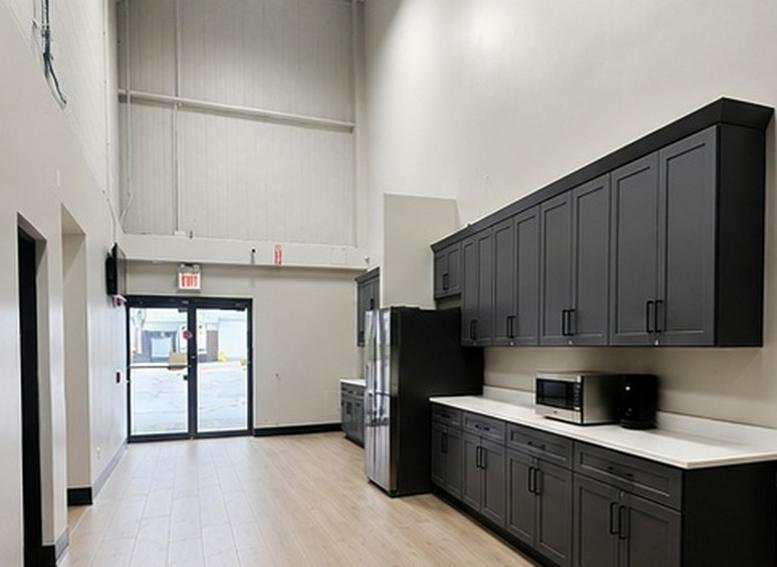 Spacious communal kitchen at 1001, Foster Avenue with dark cabinetry and high ceilings.