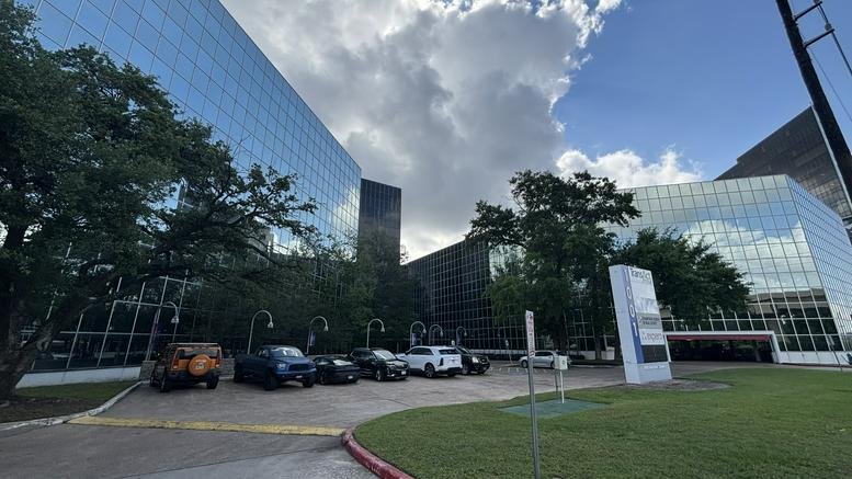 Exterior view of the modern glass-facade building at 1001 West Loop South in Houston.