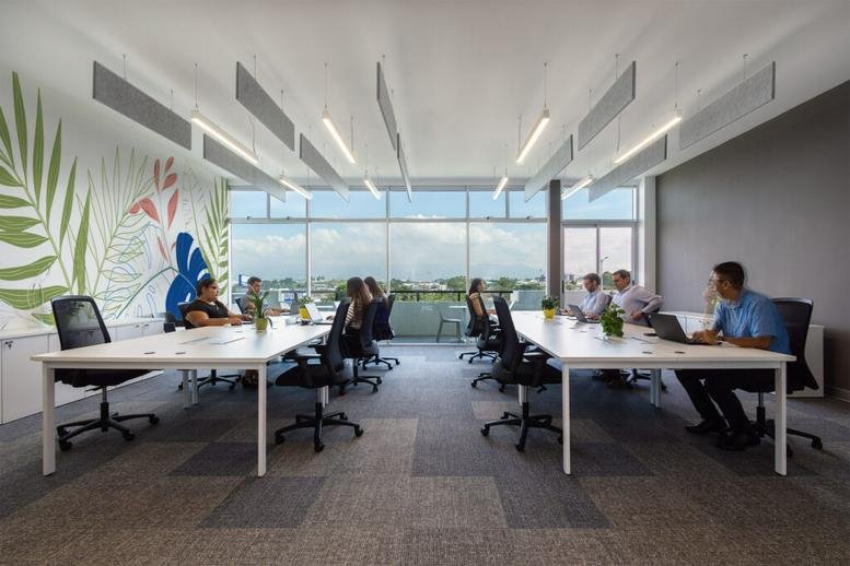 Spacious open-plan workspace at 102, Avenida 2, San Rafael de Escazú with tropical mural and mountain views.