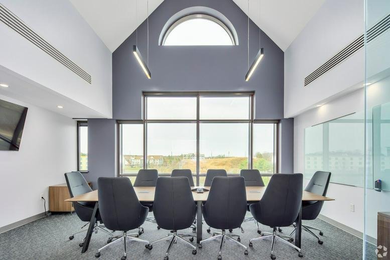 Spacious boardroom with vaulted ceilings and large arched window at 10550 Linden Lake Plaza.