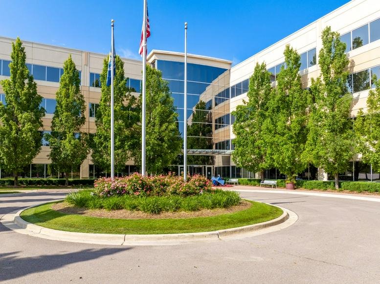 Exterior view of the multi-story office building at 1075 West Entrance Drive with manicured landscaping.