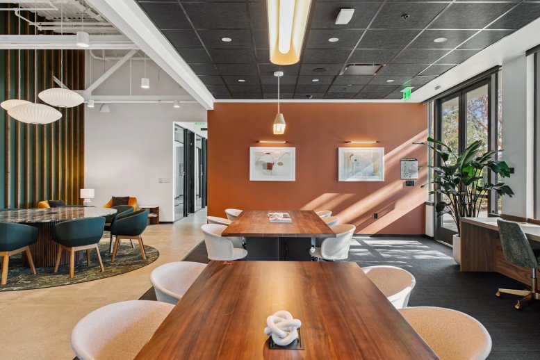Spacious communal lounge and meeting area at 1082 Post Road with an orange feature wall.