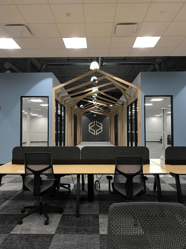 Open-plan office at 137, Glasgow Street, featuring wooden house-frame accents and modern workstations.