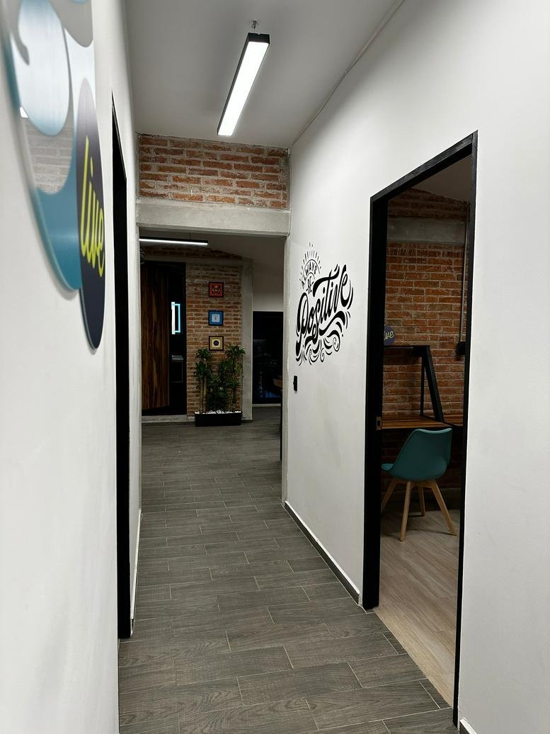 Bright hallway with white walls, creative typography decals, and a peek into an office.