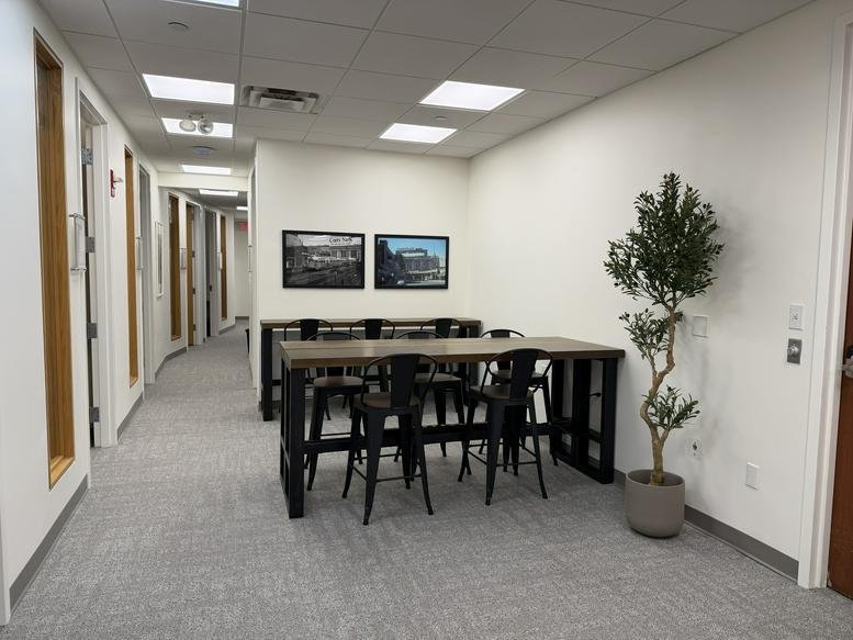 Spacious communal coworking area at 151, Merrimac Street with a large wooden table and hallway view.
