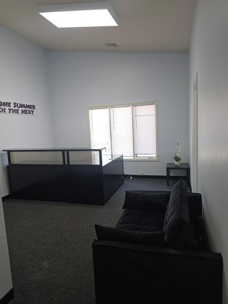 Spacious reception area at 1522 Pointer Ridge Place, A featuring a black front desk and seating.