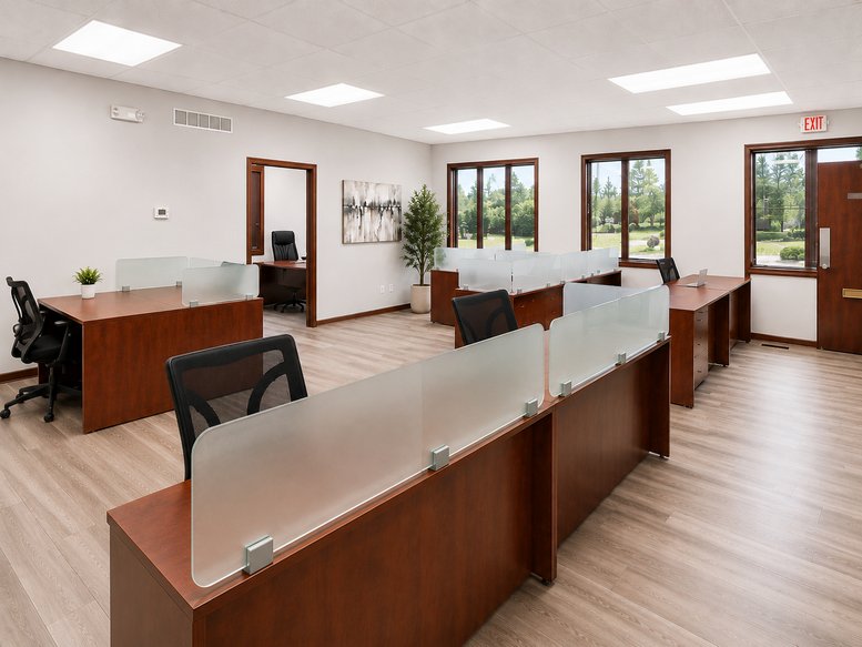 Spacious open-plan workspace at 16, Bronze Pointe North with multiple mahogany desks and frosted glass partitions.