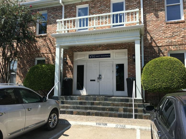 Exterior brick facade of the office building at 17766 Preston Road with white columns and balcony.