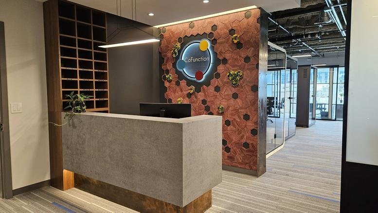 Professional reception desk at 1937, Triumph Street, featuring a branded moss wall and concrete finish.