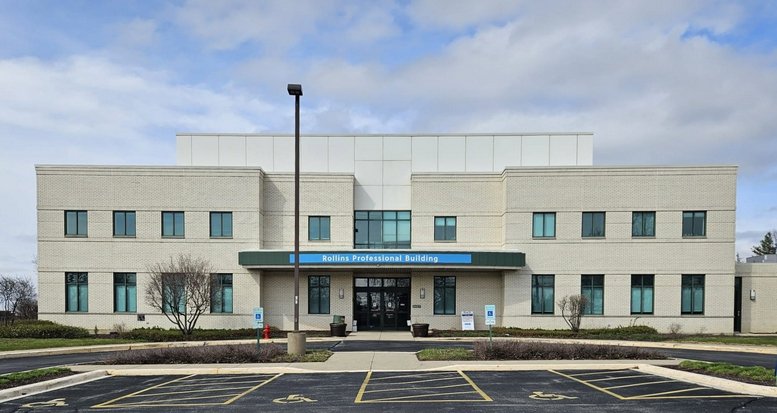 Exterior view of the Rollins Professional Building with a large parking lot and blue sky.