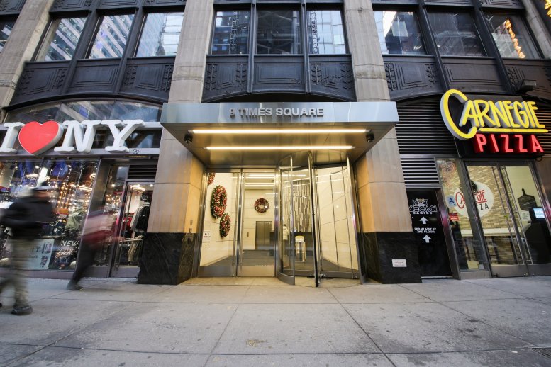 Exterior view of the street-level entrance at 9 Times Square with revolving doors.
