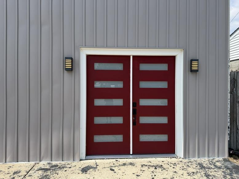 Exterior view of the red double entrance doors at 201, East Water Street.