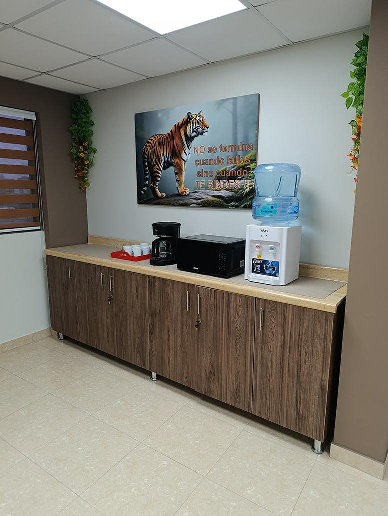 Office breakroom area with a coffee station, microwave, water dispenser, and tiger artwork.