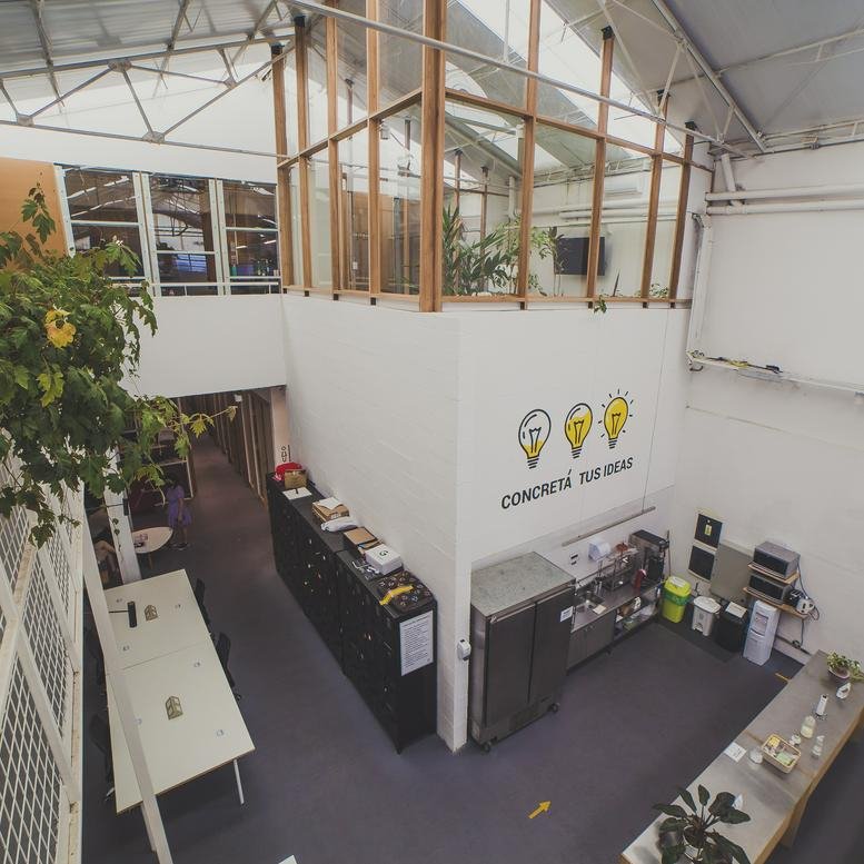 Wide interior view of the modern creative workspace at 2133, Avenida Dorrego with open-plan desks and greenery.