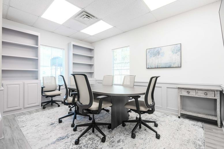 Meeting room at 22206, Highland Knolls Drive with a dark wood table, mesh chairs, and a plush patterned rug.