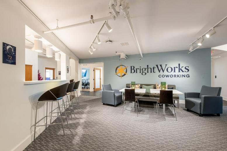 Spacious reception and lounge area at BrightWorks Coworking with modern furniture and branded wall.