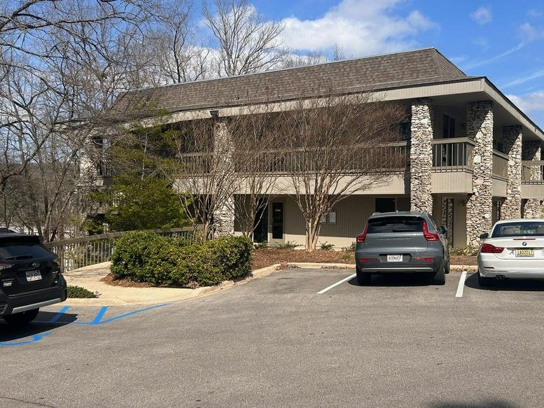 Exterior view of the stone-accented 300, Vestavia Parkway building with balcony and parking area.