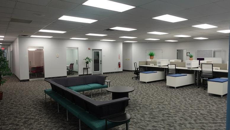 Large lobby and lounge area at 3000 East Ridge Road with modern sofas and workstation rows.