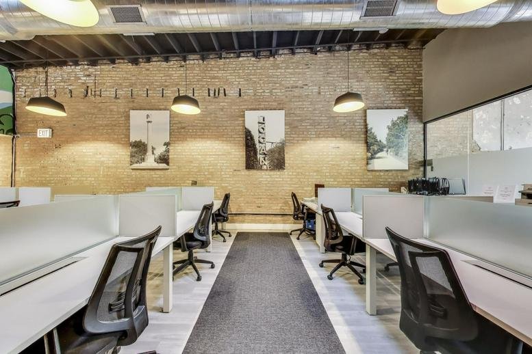Spacious open-plan workspace at 3271, West Armitage Avenue with brick walls and hanging pendant lights.