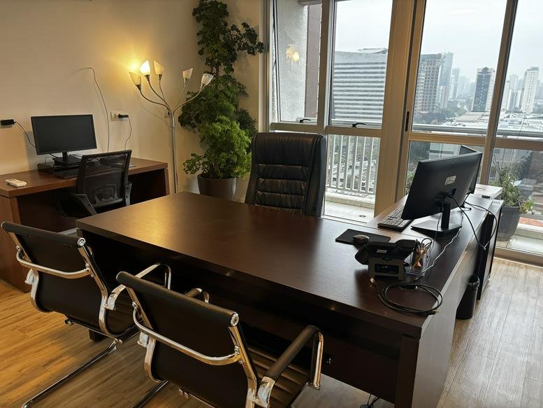 Private executive office at 472, Rua Enxovia with large wooden desk and city views.