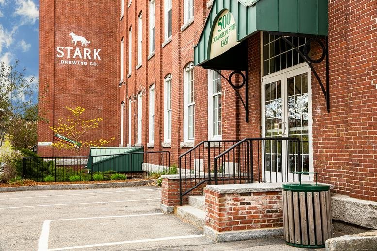 Brick exterior and main entrance of 500 North Commercial Street, Suite 502 with green awning.