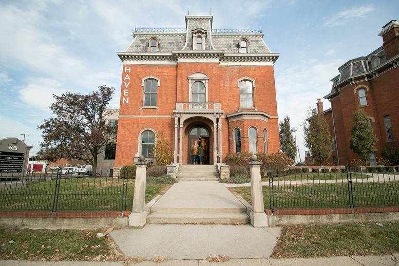 Historic red brick building exterior with a grand portico entrance.