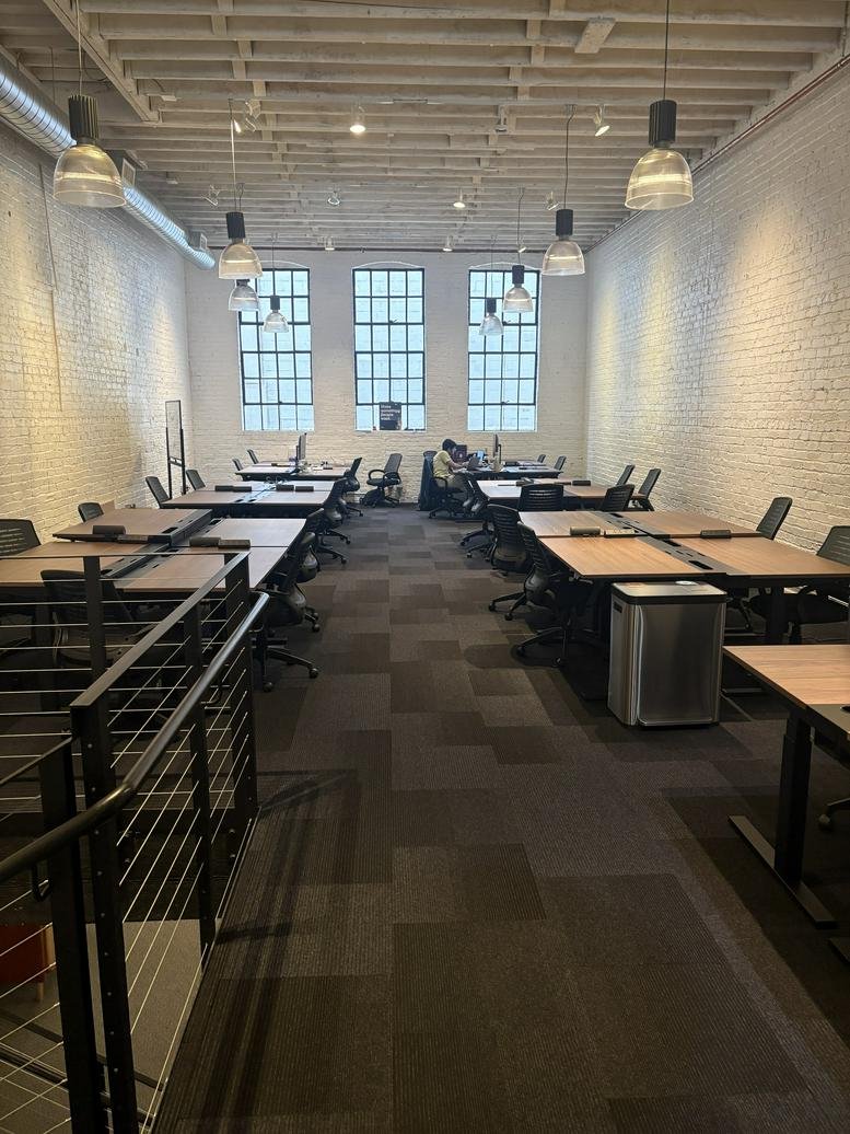 Spacious open-plan workspace at 639, Howard Street with industrial ceilings and rows of desks.