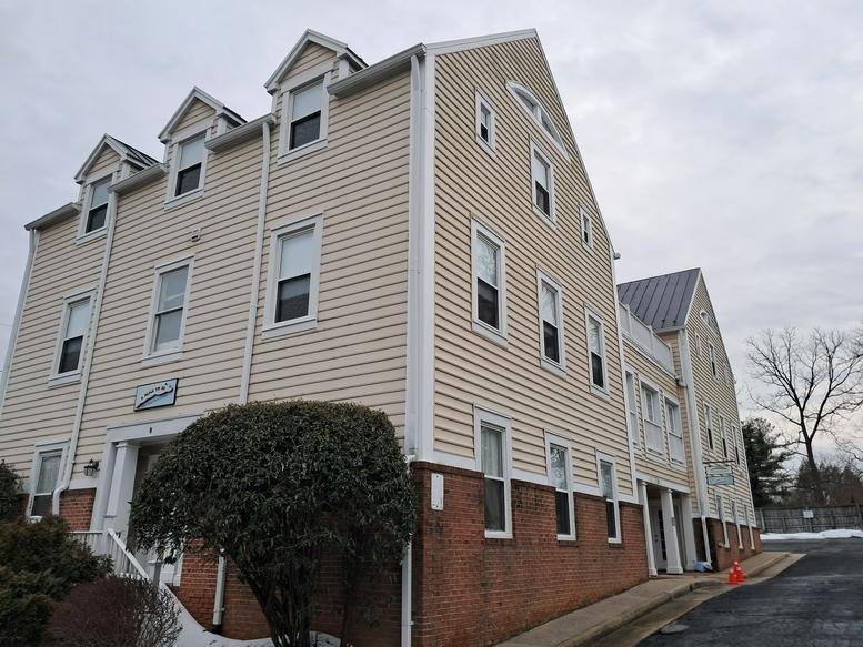 Exterior view of the tan-sided office building at 8 North Jay Street.
