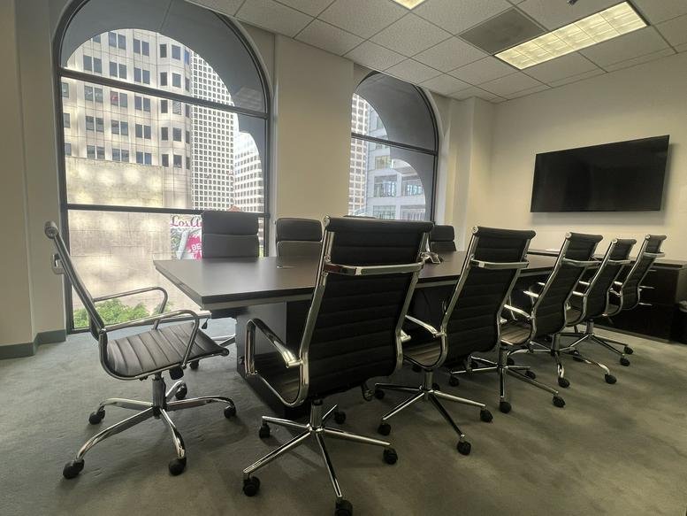 Spacious boardroom at 835 Wilshire Boulevard Suite 500 featuring arched windows and city views.
