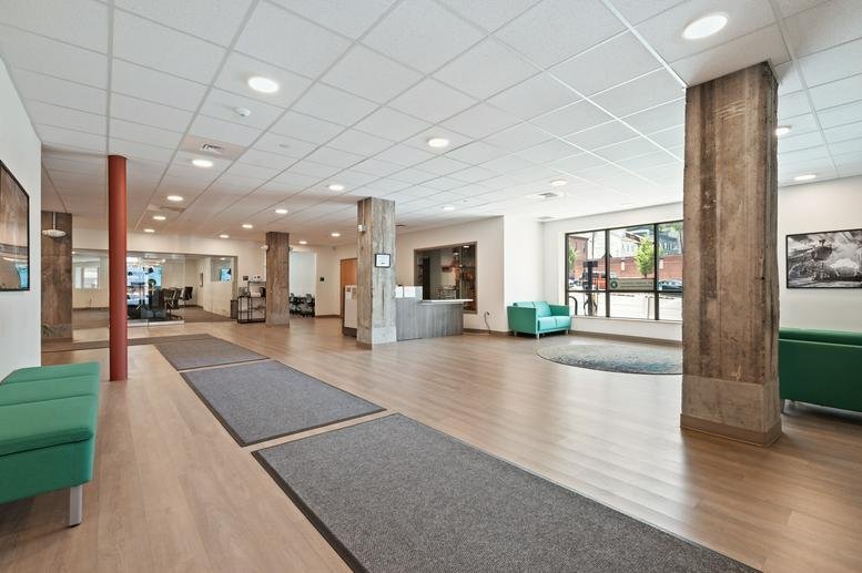 Spacious lobby area with green seating and large windows.