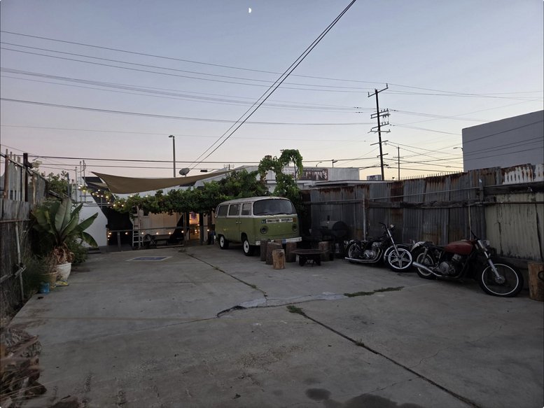 Exterior parking and patio area at 907, West Anaheim Street featuring a vintage green van.