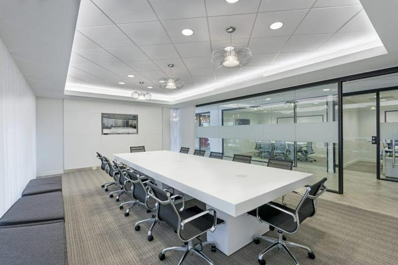 Spacious boardroom with a large white table and black chairs at 95 Merrick way, 3rd Floor.