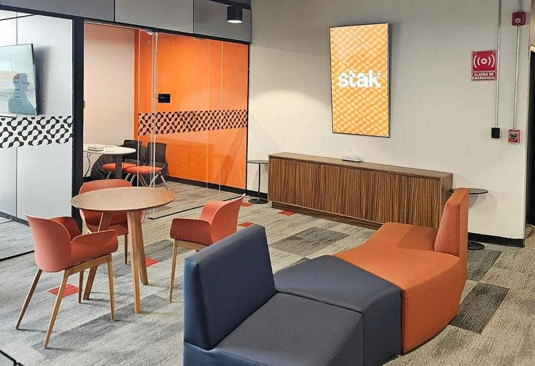 Bright lobby at Av. México 3040 - Piso 11 y 12, Juan Manuel Vallarta with orange accents and lounge seating.