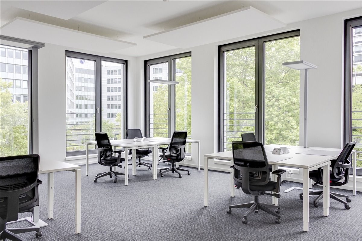 Spacious open-plan workspace at Carrera 94 # 6C-30, 2nd Floor with white desks and large windows.